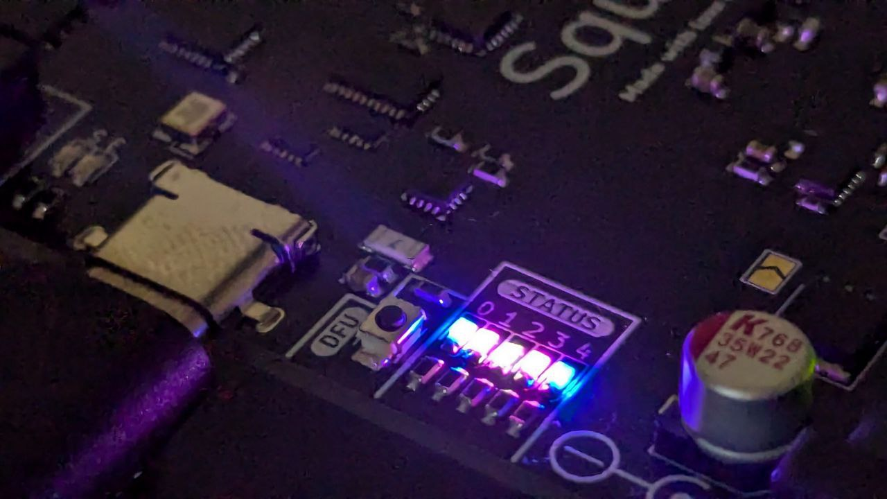 A close-up photo showing the Squishy status LEDs in the colors of the trans flag.